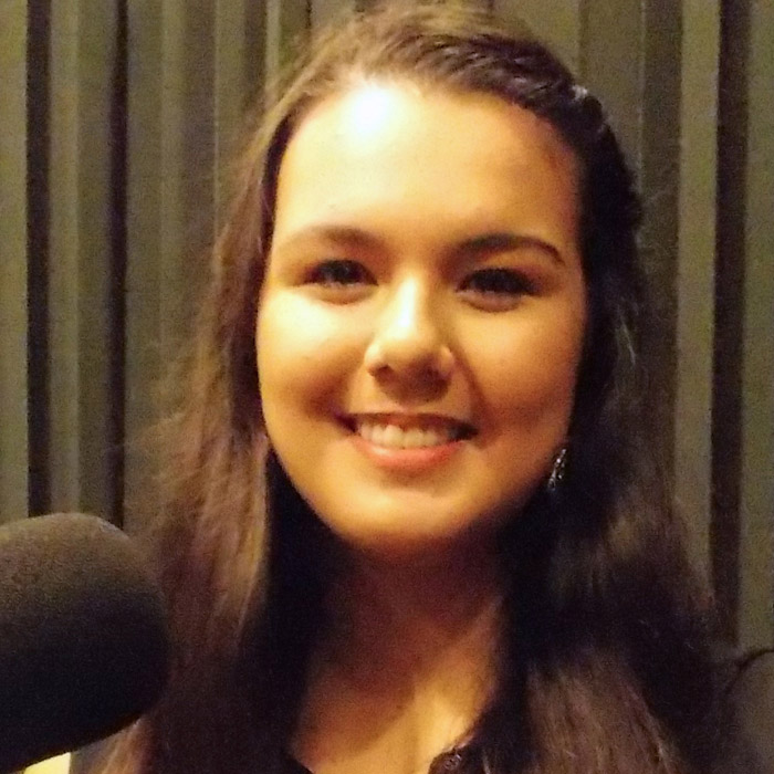 Annie Pham sitting in WFSU's radio studio in front of the mic