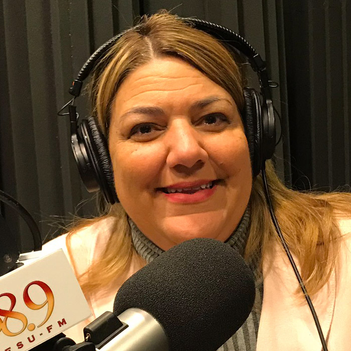 Madeline Pumariega sitting in WFSU's radio studio in front of the mic