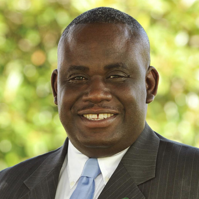 Man smiling in dark suit and tie