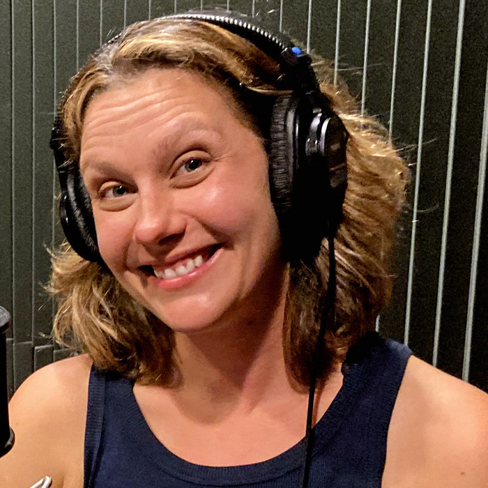 Woman smiling wearing headphones.