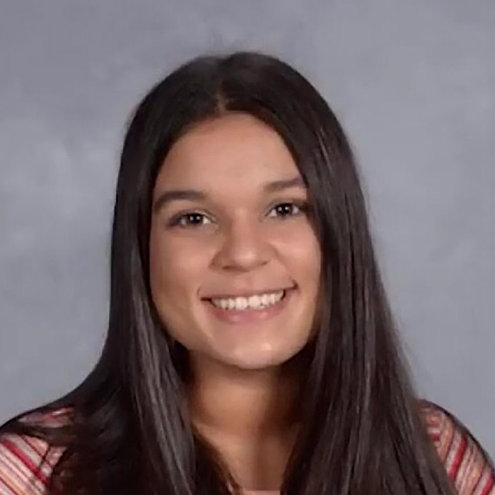 Woman smiling looking straight ahead.