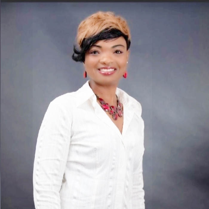 Woman smiling in front of a grey background