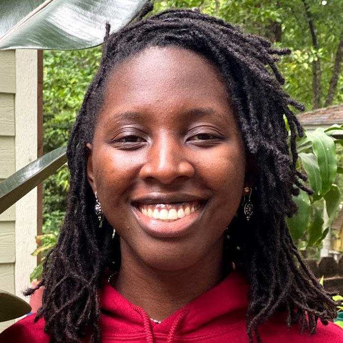 Woman smiling in red Harvard sweater.